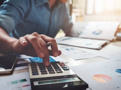 Business accounting concept, Business man using calculator with computer laptop, budget and loan paper in office.